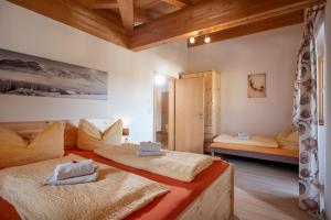 two beds in a room with wooden ceilings at Talhammerhof in Uderns