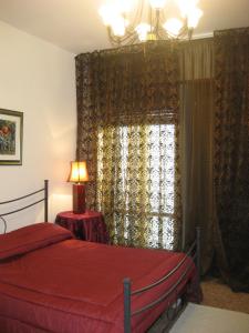 1 dormitorio con 1 cama y una ventana con cortinas en B&B Ganna, en Verona