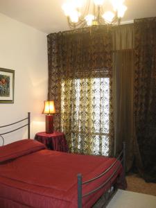 a bedroom with a bed and a window with curtains at B&B Ganna in Verona