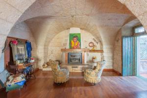 a living room with a stone fireplace and chairs at Casa Leo in Carovigno