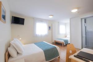 a bedroom with a bed and a desk with a laptop at Centre Jean XXIII in Annecy