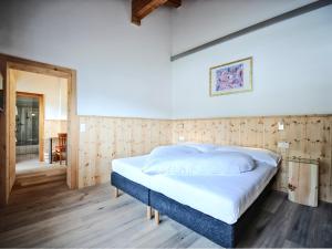 ザムナウンにあるCountry Wellnesshotel Bündnerhofの木製の壁のベッドルーム1室(ベッド1台付)