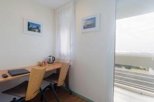 a desk with two chairs next to a window at Centre Jean XXIII in Annecy