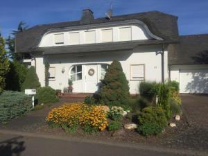 a white house with a lot of flowers in front of it at Ferienwohnung Hetzerath in Hetzerath