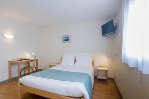 a bedroom with a bed and a table and a window at Centre Jean XXIII in Annecy