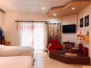 ein Schlafzimmer mit einem Bett und einem TV in einem Zimmer in der Unterkunft Matsu B&B in Insel Nangan