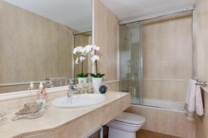 ein Badezimmer mit Waschbecken, Toilette und Spiegel in der Unterkunft Bonanza 5 in Colonia Sant Jordi