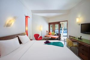 勒吉安的住宿－ibis Styles Bali Legian - CHSE Certified，一间卧室配有一张床、一张书桌和一台电视