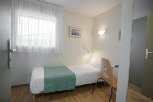 a bedroom with a bed and a desk and a window at Centre Jean XXIII in Annecy