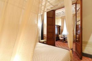 a bedroom with a canopy bed with a mirror at Uffizi Harmony in Florence