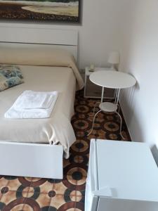 Dormitorio pequeño con cama y mesa en Hotel Rosy en Battipaglia