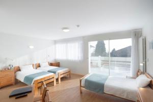 a bedroom with two beds and a large window at Centre Jean XXIII in Annecy