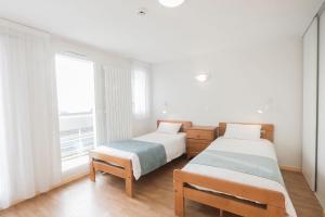 two beds in a room with a window at Centre Jean XXIII in Annecy