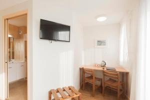 a dining room with a table and a television on a wall at Centre Jean XXIII in Annecy