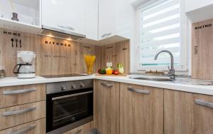 a kitchen with wooden cabinets and a sink at Holiday house CIRIK in Kras