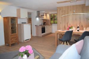 Landhaus Senn في فوسن: مطبخ وغرفة معيشة مع طاولة وكراسي