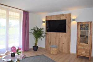een woonkamer met een flatscreen-tv aan de muur bij Landhaus Senn in Füssen