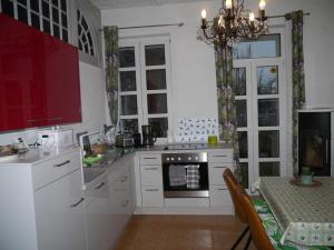 uma cozinha com armários brancos, uma mesa e um lustre em Ferienwohnung im Neubauernweg 3 em Hoppegarten
