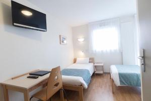 a small room with two beds and a desk at Centre Jean XXIII in Annecy