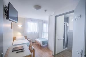 a small room with a bedroom with a bed and a table at Centre Jean XXIII in Annecy