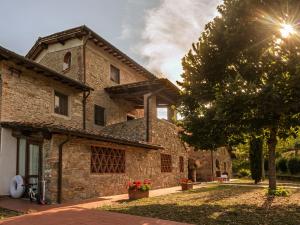een stenen huis met een boom ervoor bij Villa Norcenni ApartHotel in Figline Valdarno