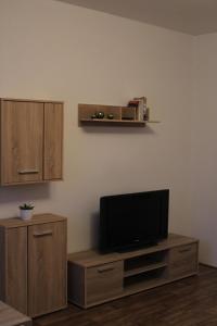 a living room with a flat screen tv on a cabinet at Apartmány Toufar in Telč
