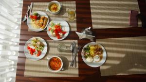 una mesa de madera con platos de comida. en Resort Iksha en Iksha