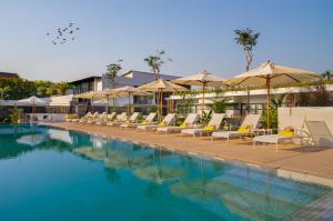 uma piscina com espreguiçadeiras e guarda-sóis em The Aviary Hotel em Siem Reap