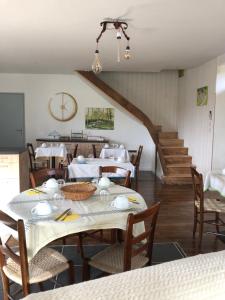 jadalnia ze stołem, krzesłami i schodami w obiekcie Le Moulin de Lassalle w mieście Curemonte