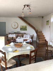 a dining room with a table and chairs and a staircase at Le Moulin de Lassalle in Curemonte