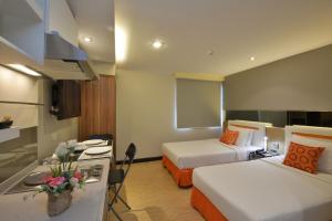 a hotel room with two beds and a kitchen at Arawana Express Phromphong in Bangkok