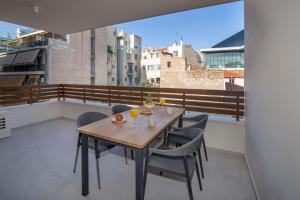 a wooden table and chairs on a balcony at Acropolis Golden Suites by GHH in Athens