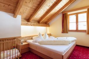 a bedroom with a bed and a crib at Kinderhotel Laderhof in Ladis +161 photos