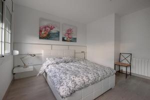 1 dormitorio con 1 cama y 2 cuadros en la pared en Kamelly, en Badalona