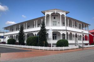 a white building with a gazebo on a street at Villa Minna in Göhren