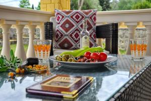 a glass table with a plate of vegetables on a patio at Villa Zoi in Pelekas