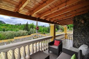 a balcony with a chair and a red pillow at Villa Zoi in Pelekas