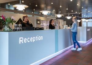 a group of people standing at a reception counter at Pharmakon Hotel & Conferencecenter in Hillerød