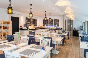 a restaurant with white tables and chairs and a counter at Hotel San Sebastián Orly, Affiliated by Meliá in Donostia-San Sebastián