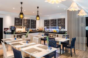 a restaurant with tables and chairs and a counter at Hotel San Sebastián Orly, Affiliated by Meliá in Donostia-San Sebastián