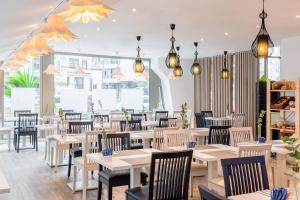 a restaurant with tables and chairs and lights at Hotel San Sebastián Orly, Affiliated by Meliá in Donostia-San Sebastián