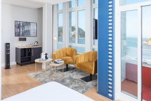 a living room with two chairs and a table at Hotel San Sebastián Orly, Affiliated by Meliá in Donostia-San Sebastián