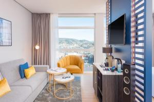 a living room with a couch and a tv at Hotel San Sebastián Orly, Affiliated by Meliá in Donostia-San Sebastián