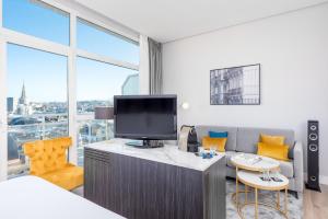 a hotel room with a tv and a couch and a bed at Hotel San Sebastián Orly, Affiliated by Meliá in Donostia-San Sebastián