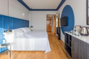 a bedroom with a large white bed and a tv at Hotel San Sebastián Orly, Affiliated by Meliá in Donostia-San Sebastián