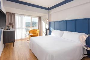 a bedroom with a large white bed and a desk at Hotel San Sebastián Orly, Affiliated by Meliá in Donostia-San Sebastián