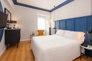 a bedroom with a large white bed and blue walls at Hotel San Sebastián Orly, Affiliated by Meliá in Donostia-San Sebastián