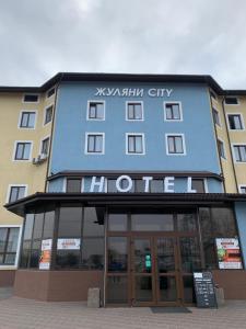 a blue building with a sign on the front of it at Zhuliany City Hotel in Kyiv