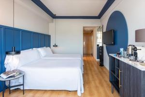 a bedroom with a white bed and a blue wall at Hotel San Sebastián Orly, Affiliated by Meliá in Donostia-San Sebastián