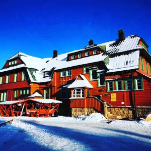a large wooden building with snow on it at Auersberg Haus in Eibenstock
